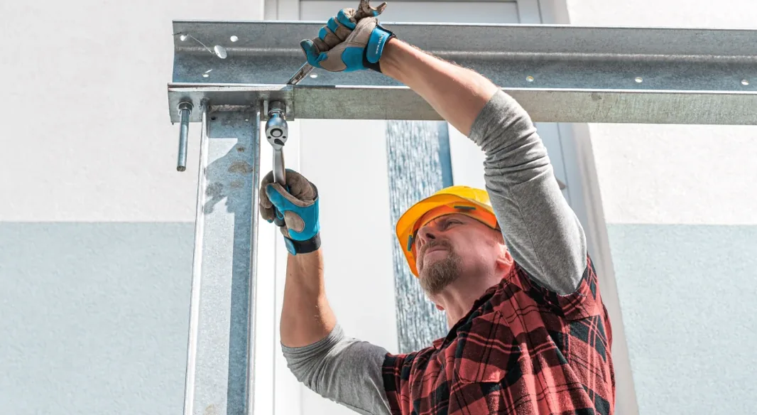 Installer fixing a light gauge steel stud panel by hand