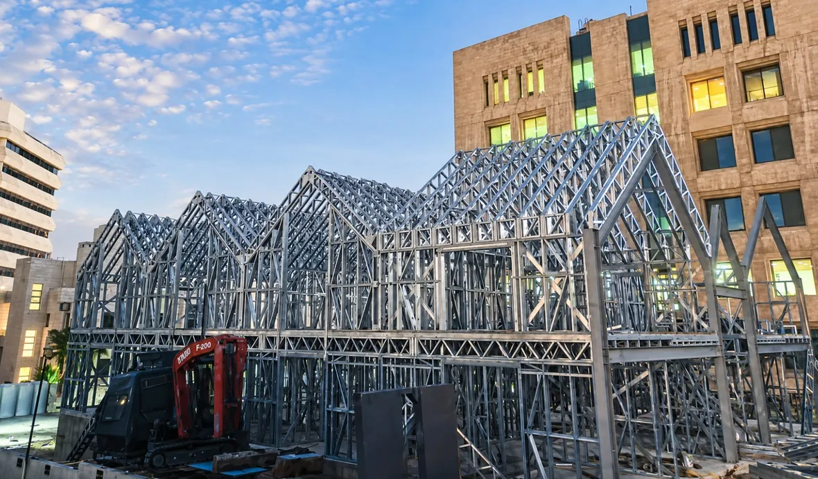 Light gauge steel roof trusses on an urban rooftop development at dusk