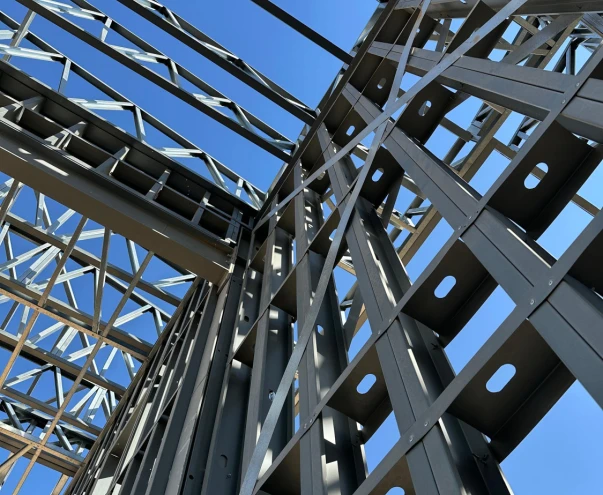 Looking up at a light gauge steel roof frame against the sky
